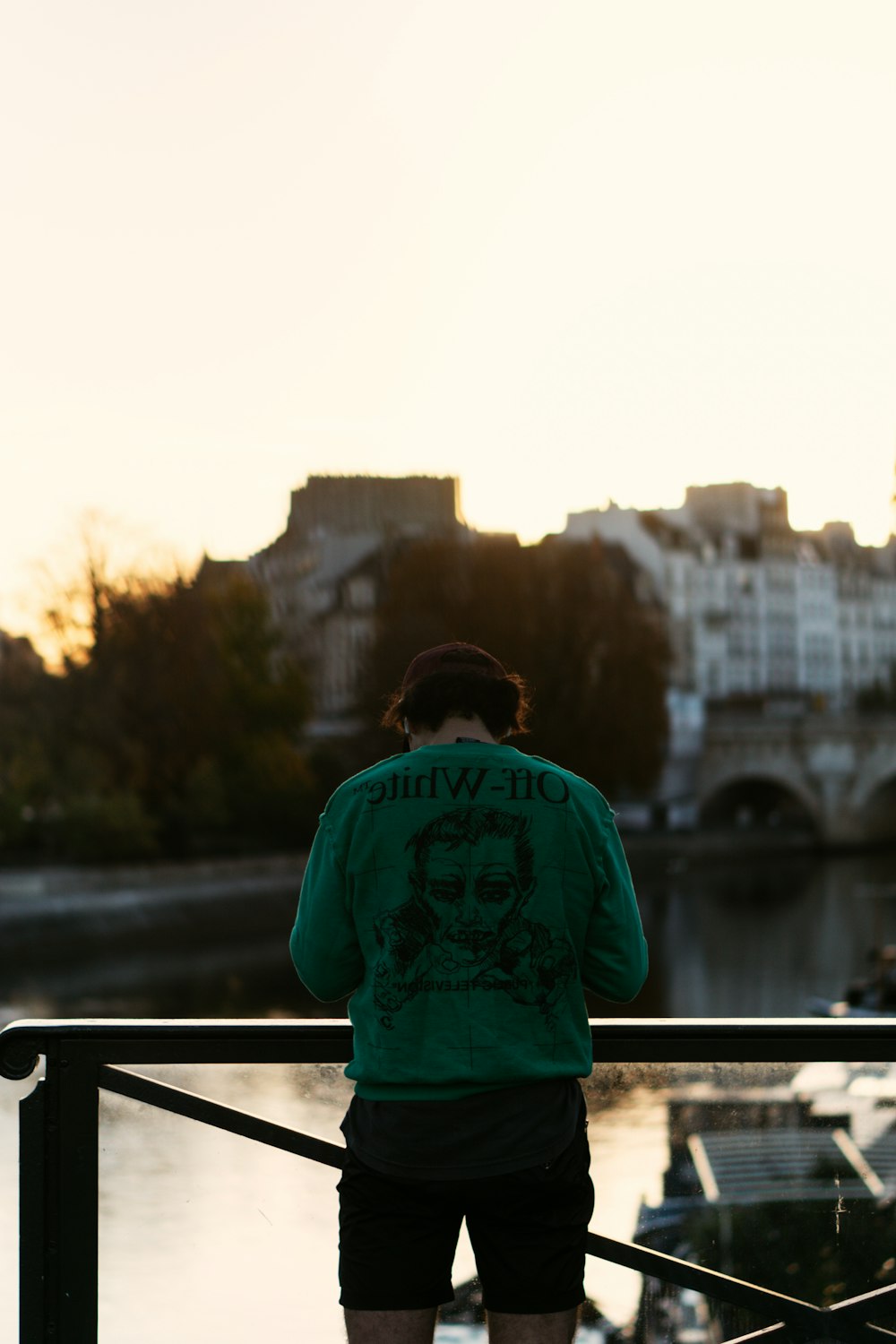 a man standing on a bridge looking at the water