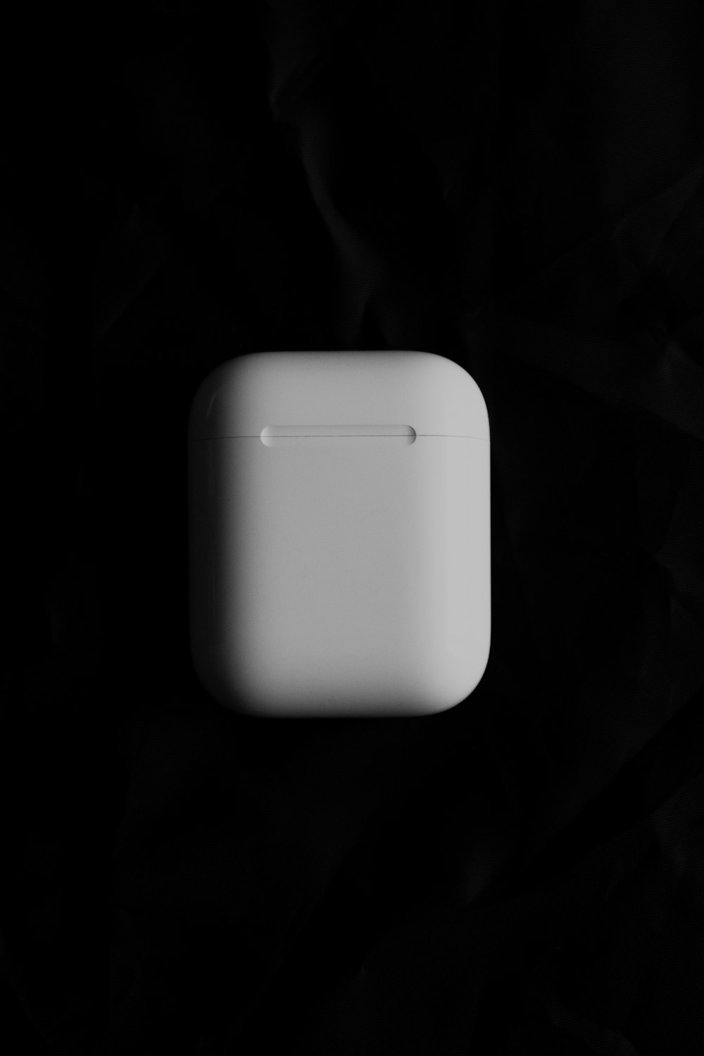 an apple airpods sitting on top of a black surface