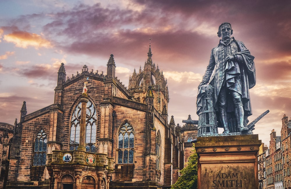 uma estátua de um homem em pé na frente de um edifício