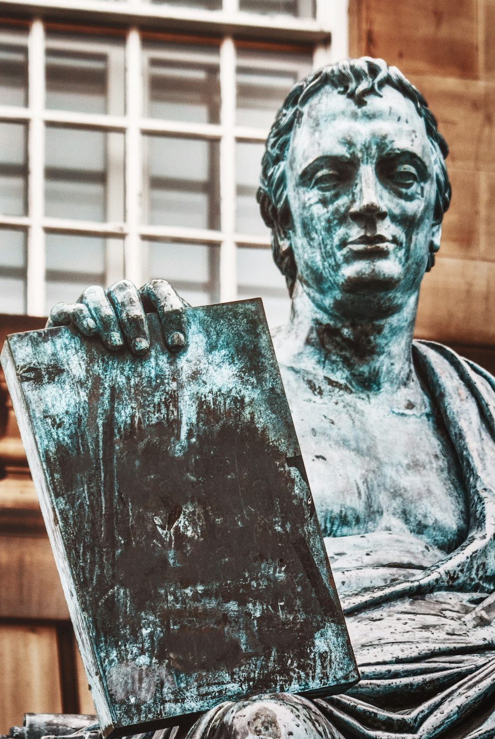 Una estatua de un hombre sosteniendo un pedazo de papel