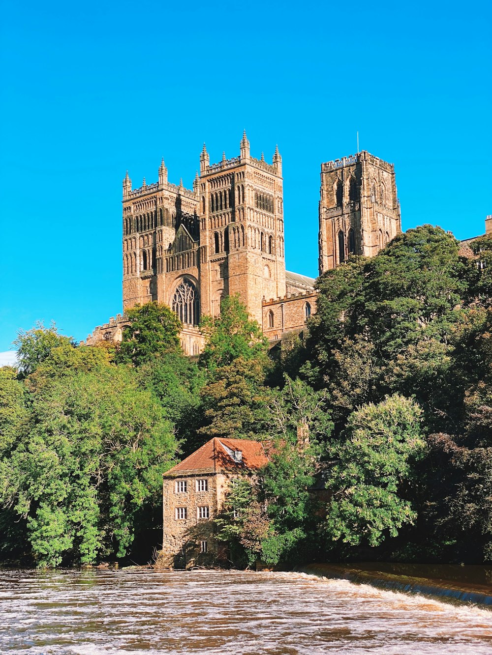 a large building sitting on top of a lush green hillside