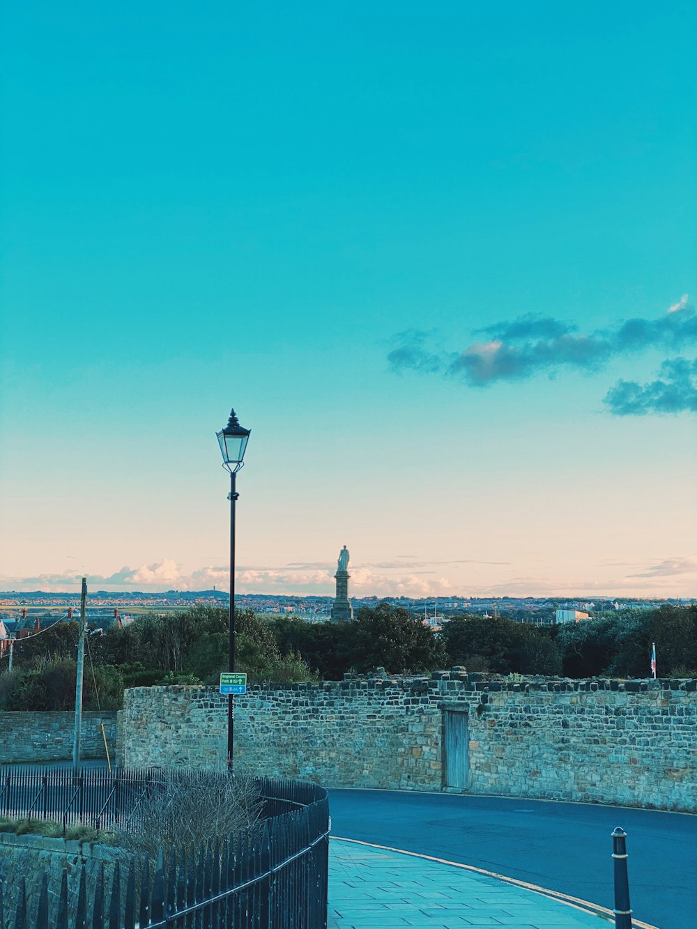 a street light sitting next to a stone wall