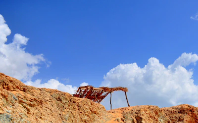 a rusted structure sitting on top of a rocky hill