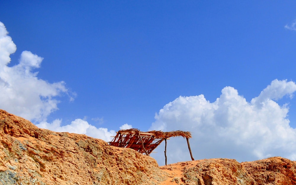 a rusted structure sitting on top of a rocky hill