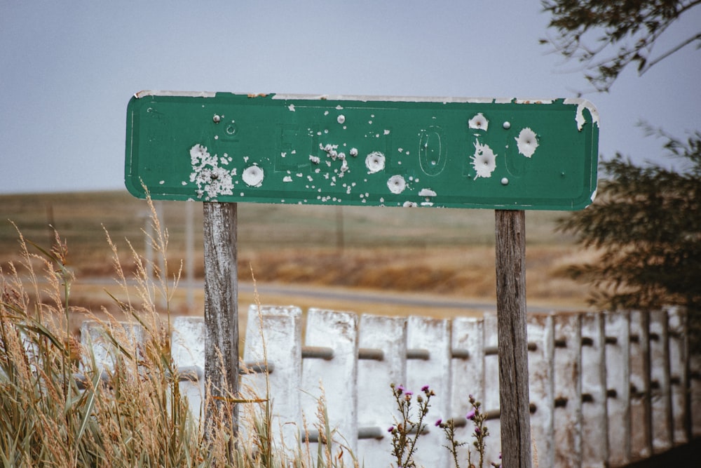 a green street sign sitting on the side of a road