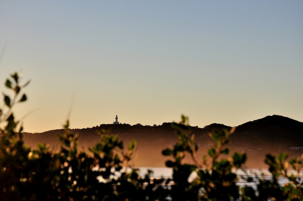 a view of a hill with a clock tower in the distance