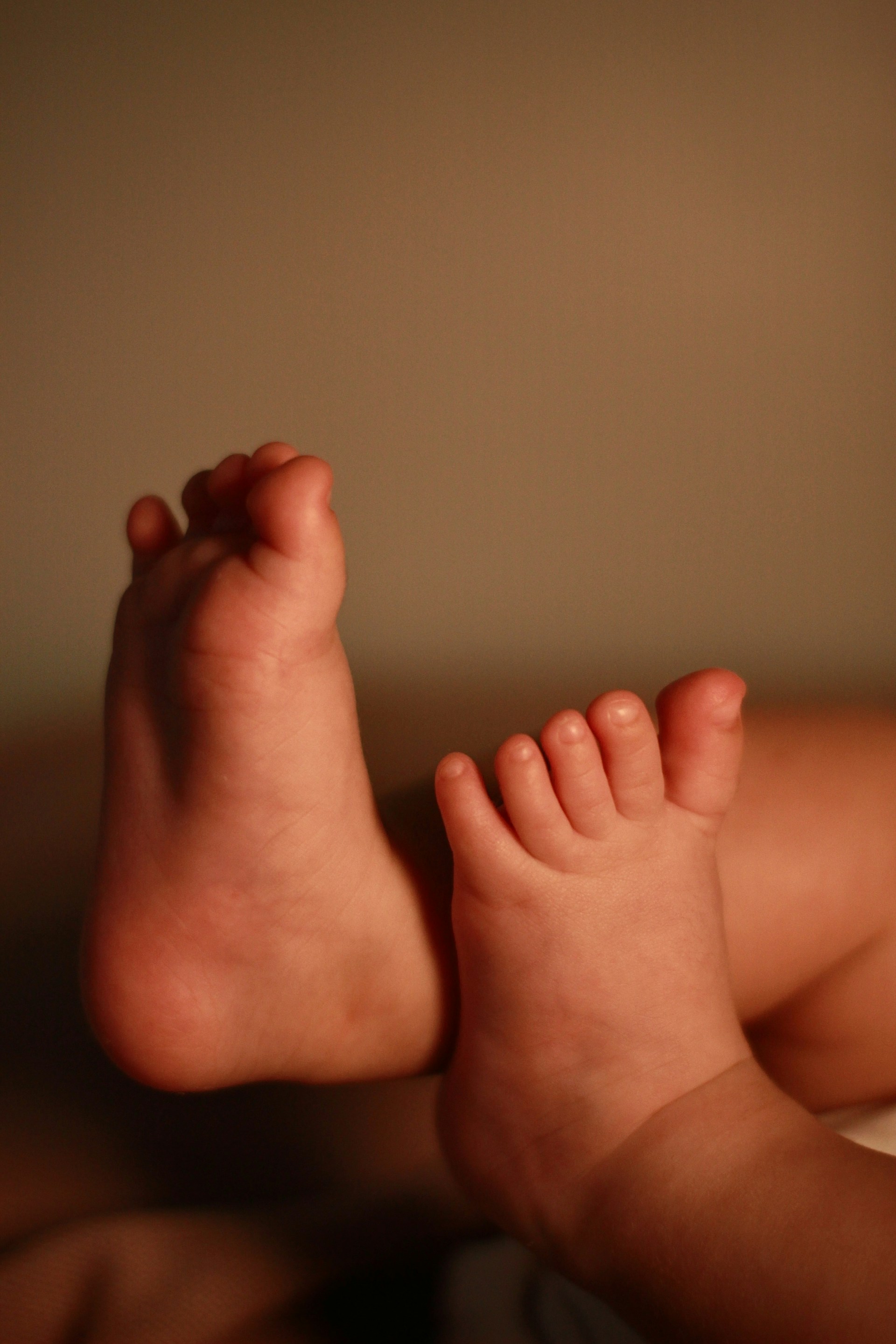 a close up of a baby's bare feet on a bed