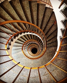 a spiral staircase in a building with stone floors
