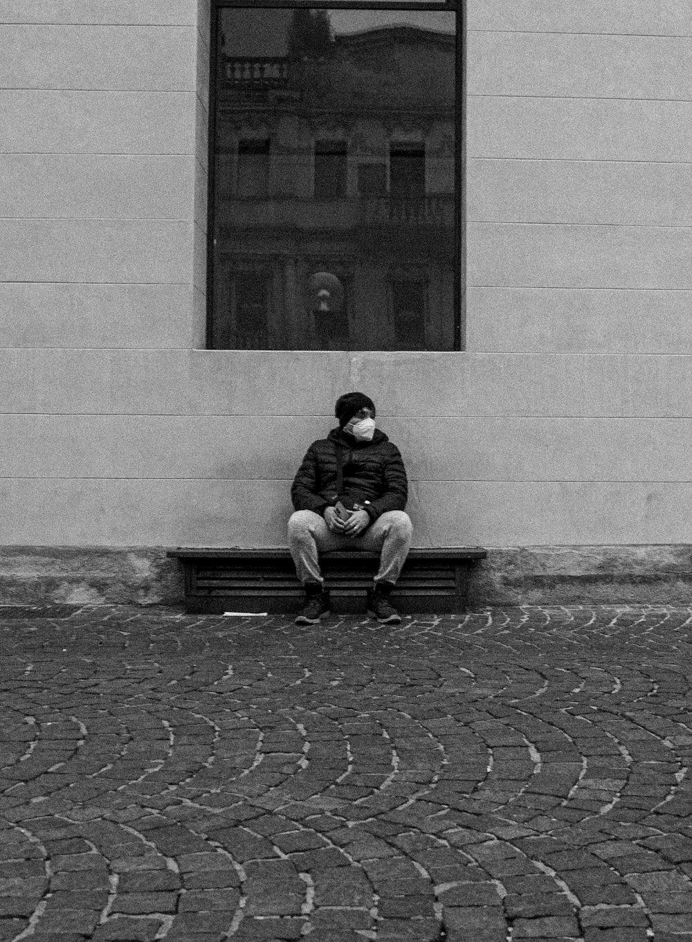 a man sitting on a bench in front of a window