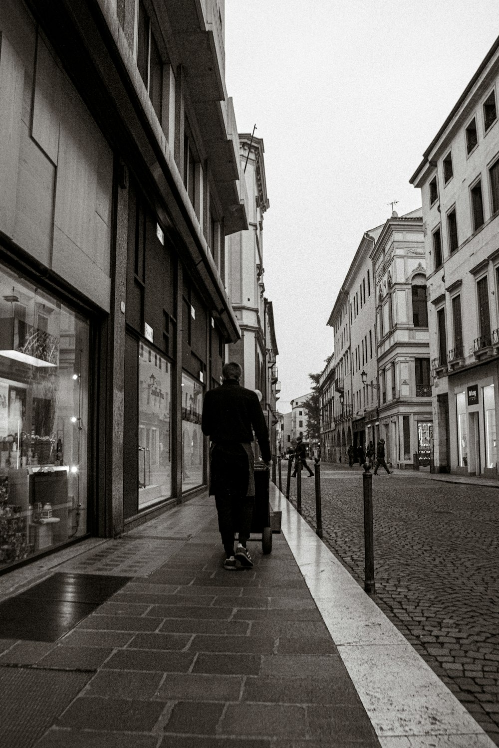 a person walking down a sidewalk with a suitcase