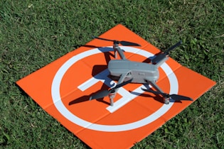a remote controlled flying device on top of an orange sign