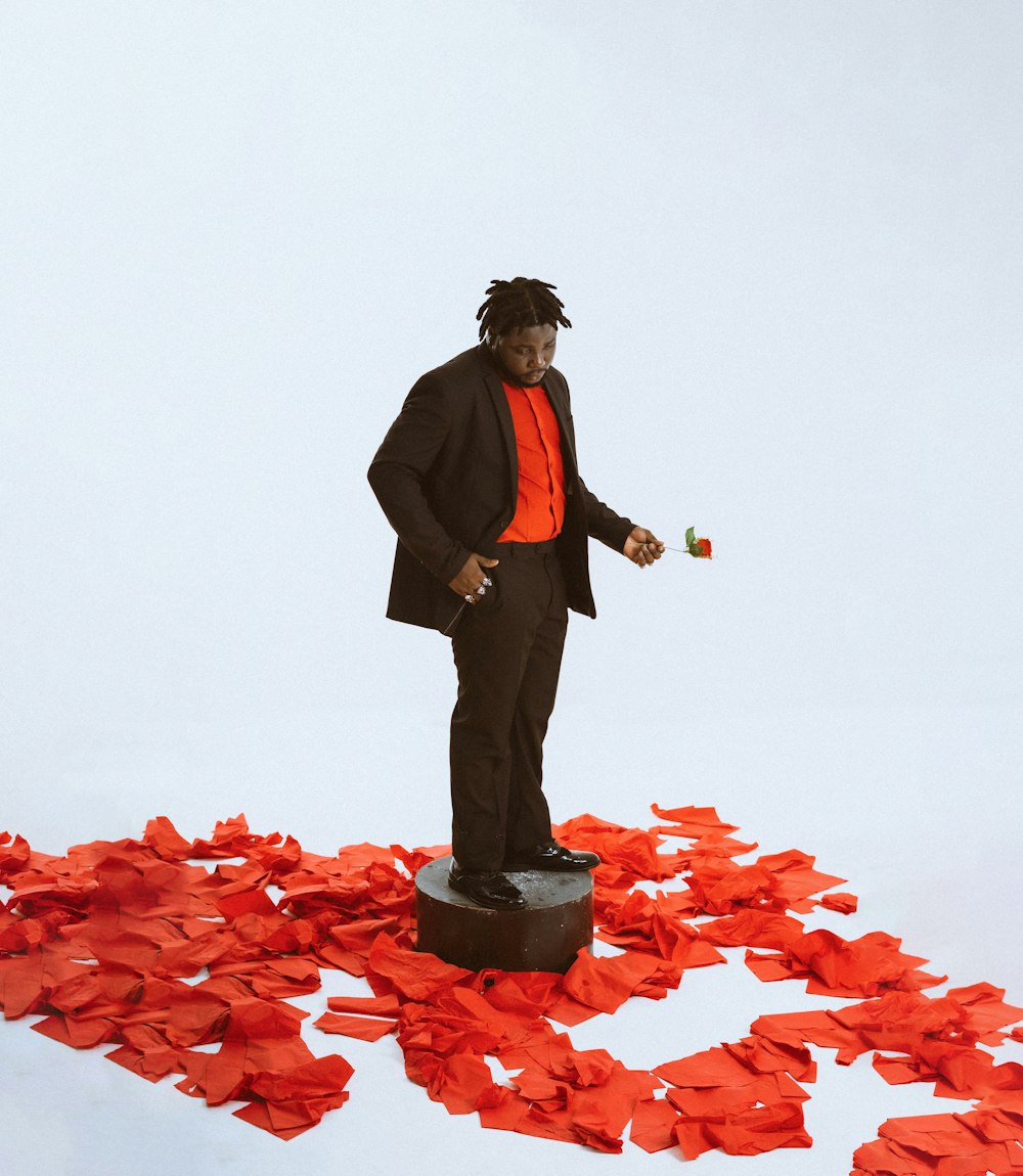 a man standing on top of a pile of red paper