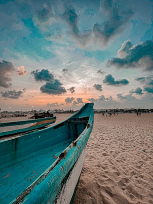 a boat sitting on top of a sandy beach
