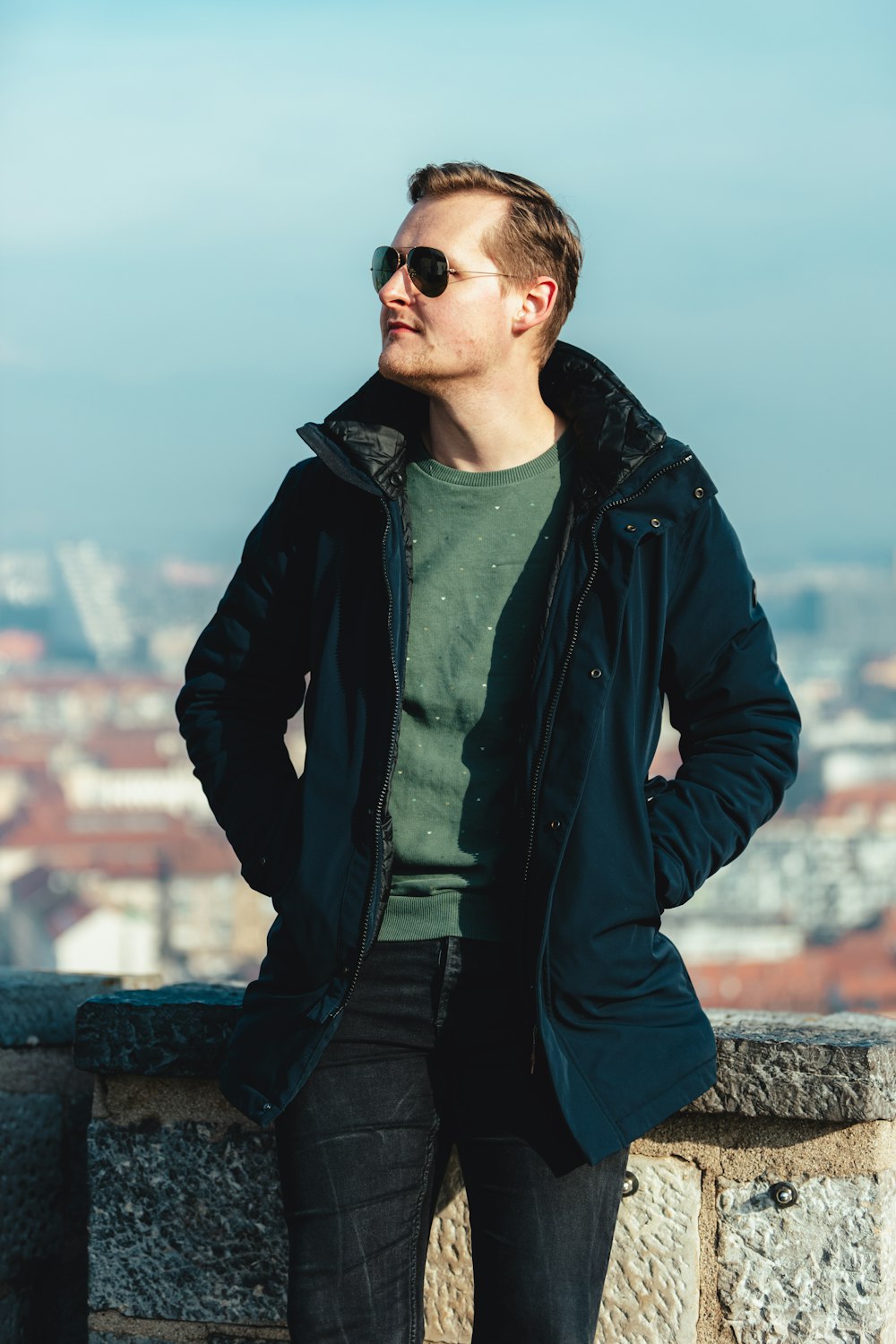 a man standing on a ledge with his hands in his pockets