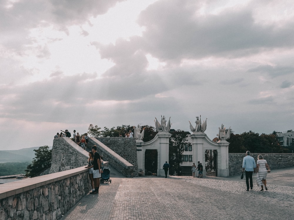 a group of people standing on top of a stone bridge