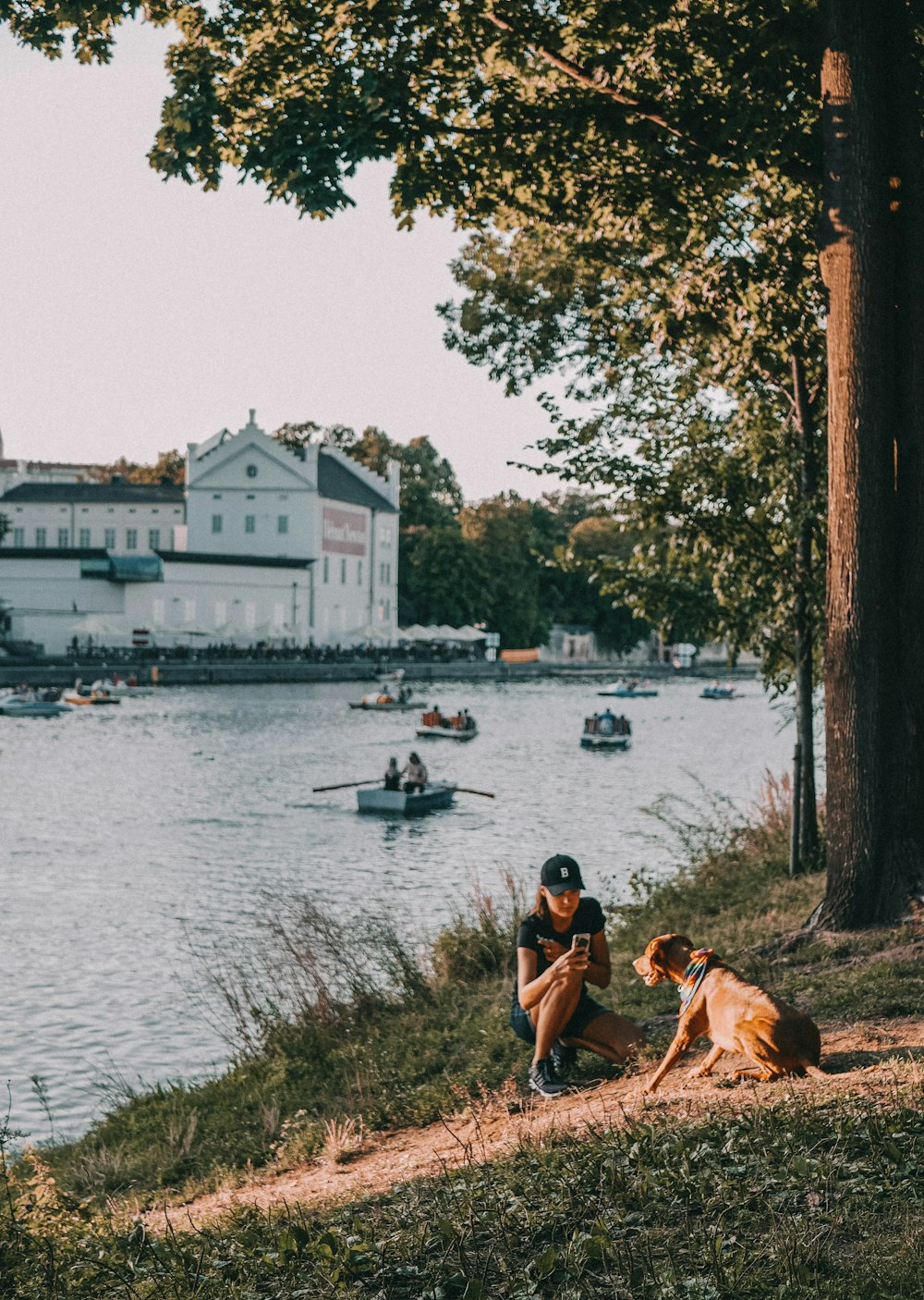 a couple of people sitting next to a lake