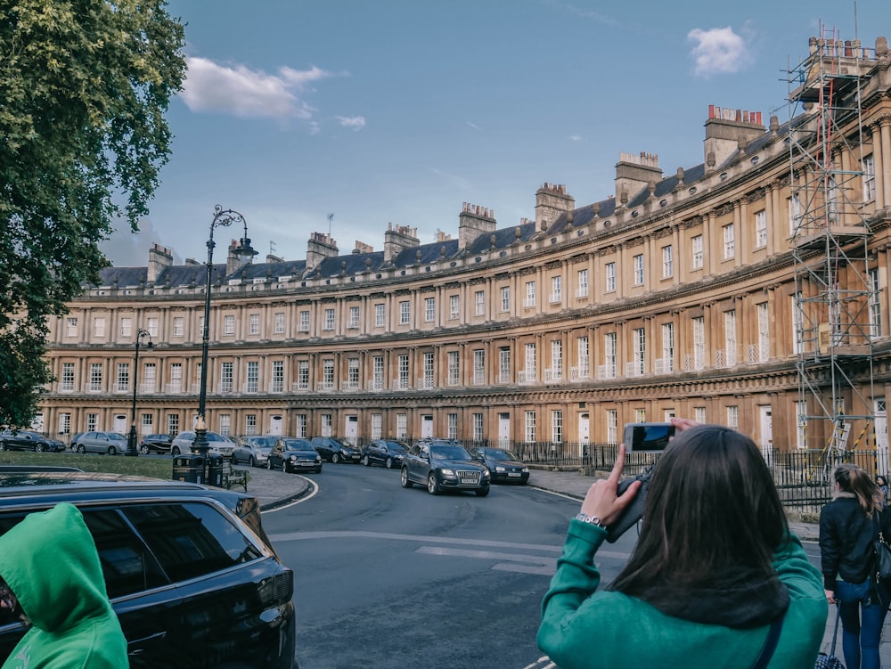 a woman taking a picture of a row of buildings