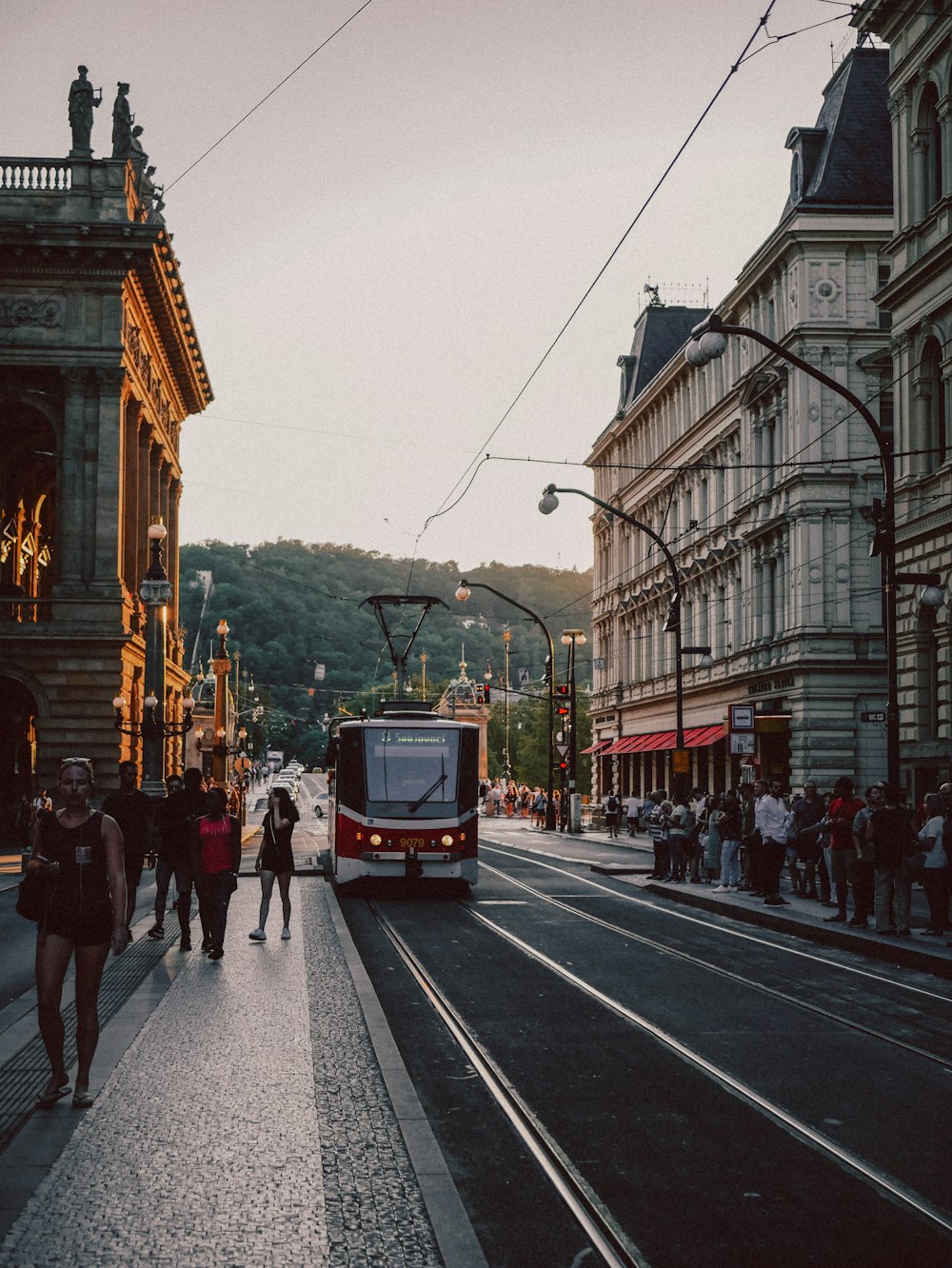 a city street with a bus and people walking on the sidewalk