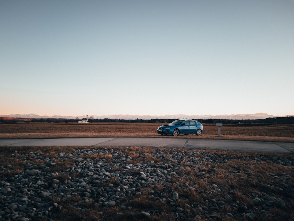 a blue car is parked on the side of the road