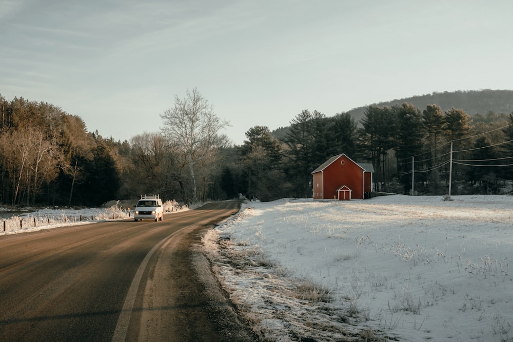 a truck driving down a snow covered road