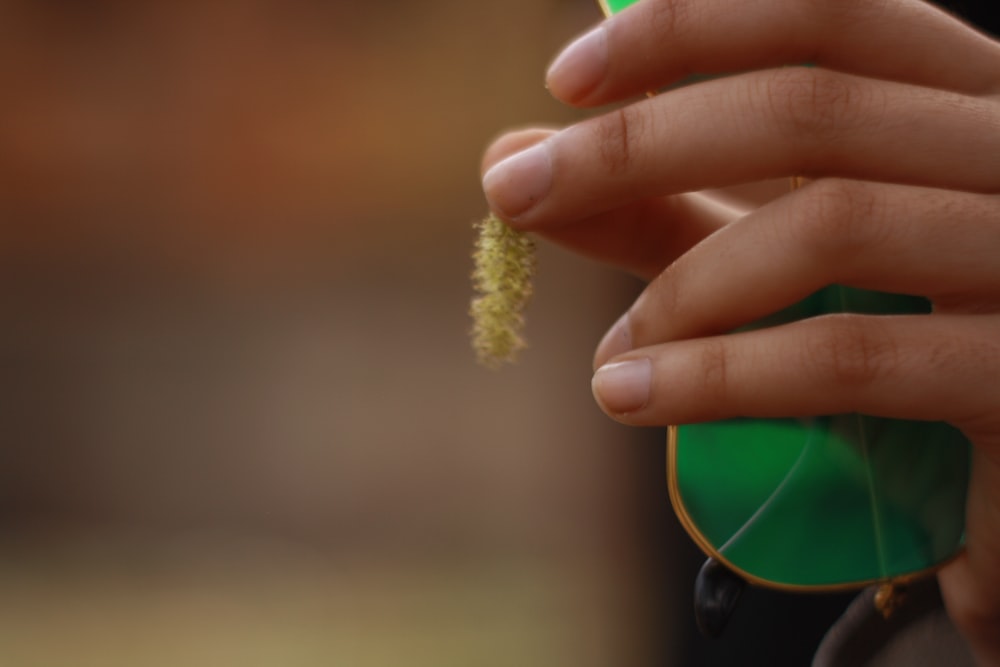 a close up of a person holding a green object