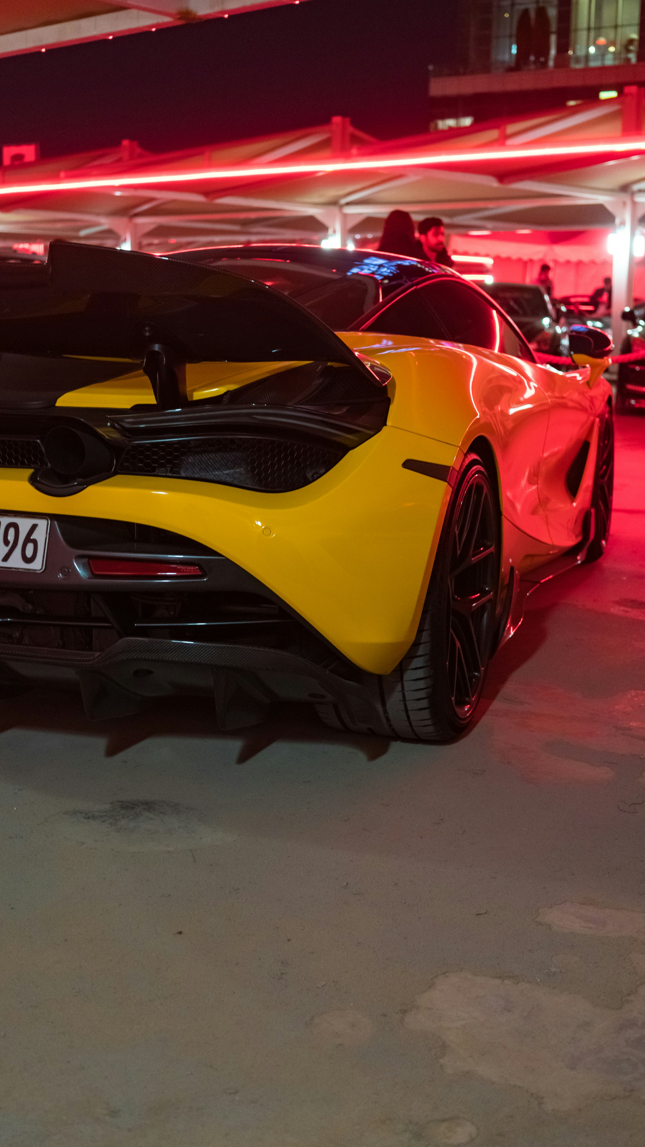 a yellow and black sports car parked in a garage