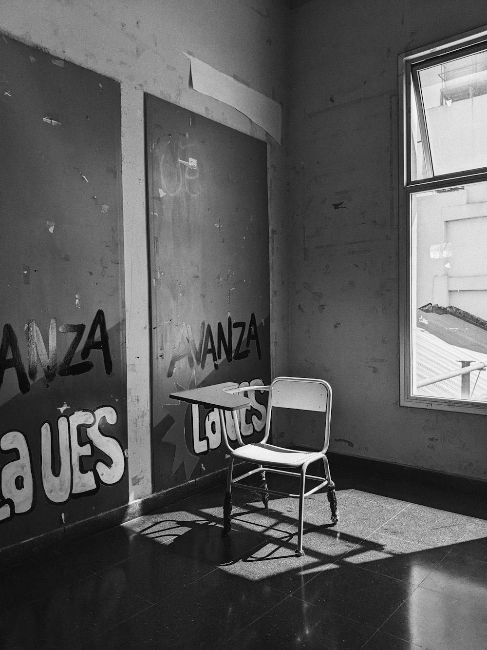 a black and white photo of a chair and a window