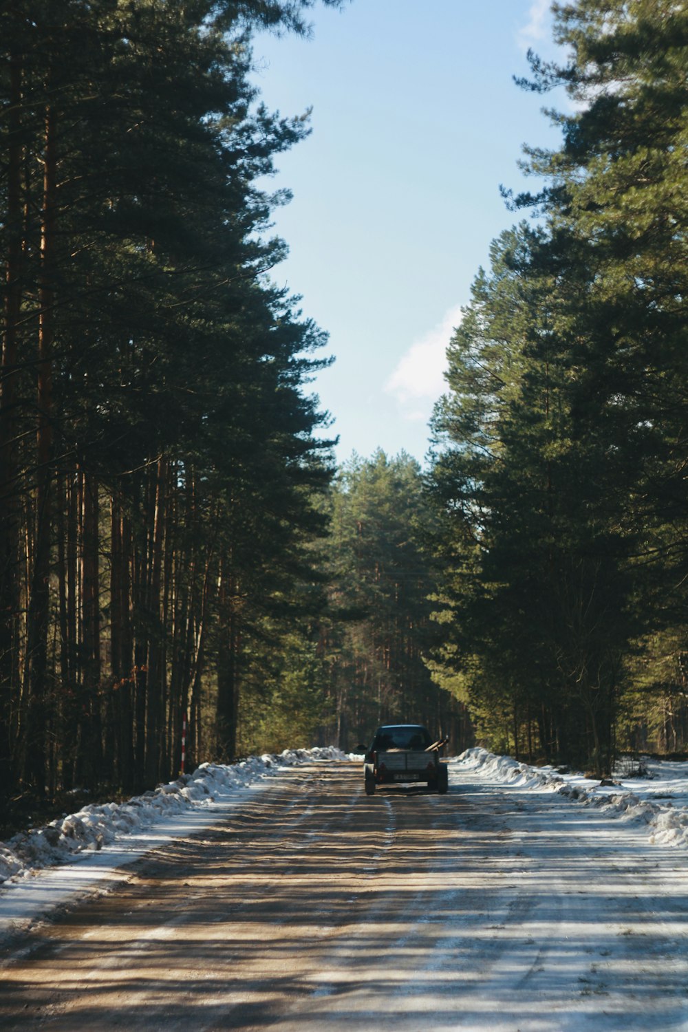 a truck driving down a snow covered road