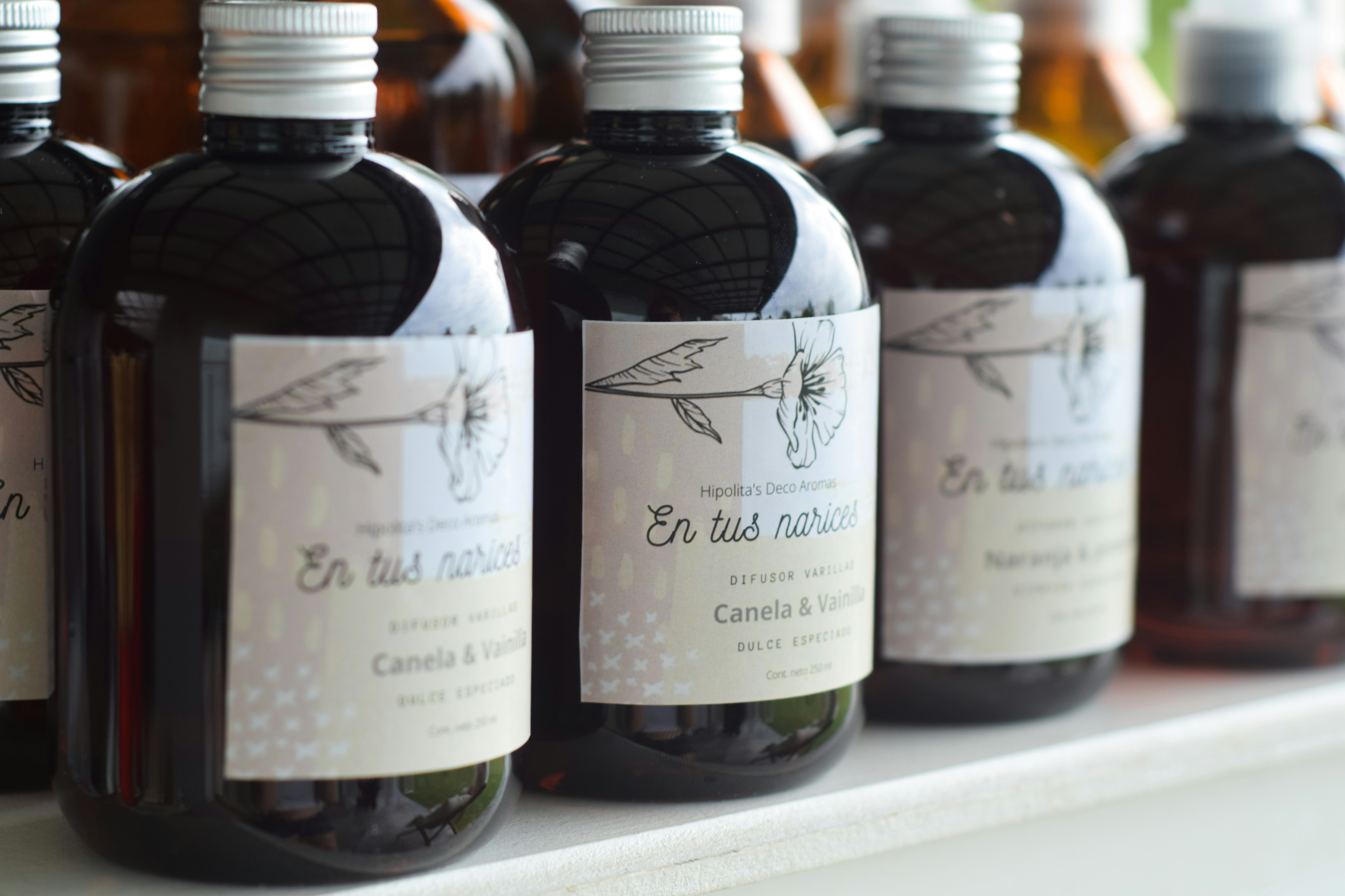 a row of bottles of liquid sitting on a shelf