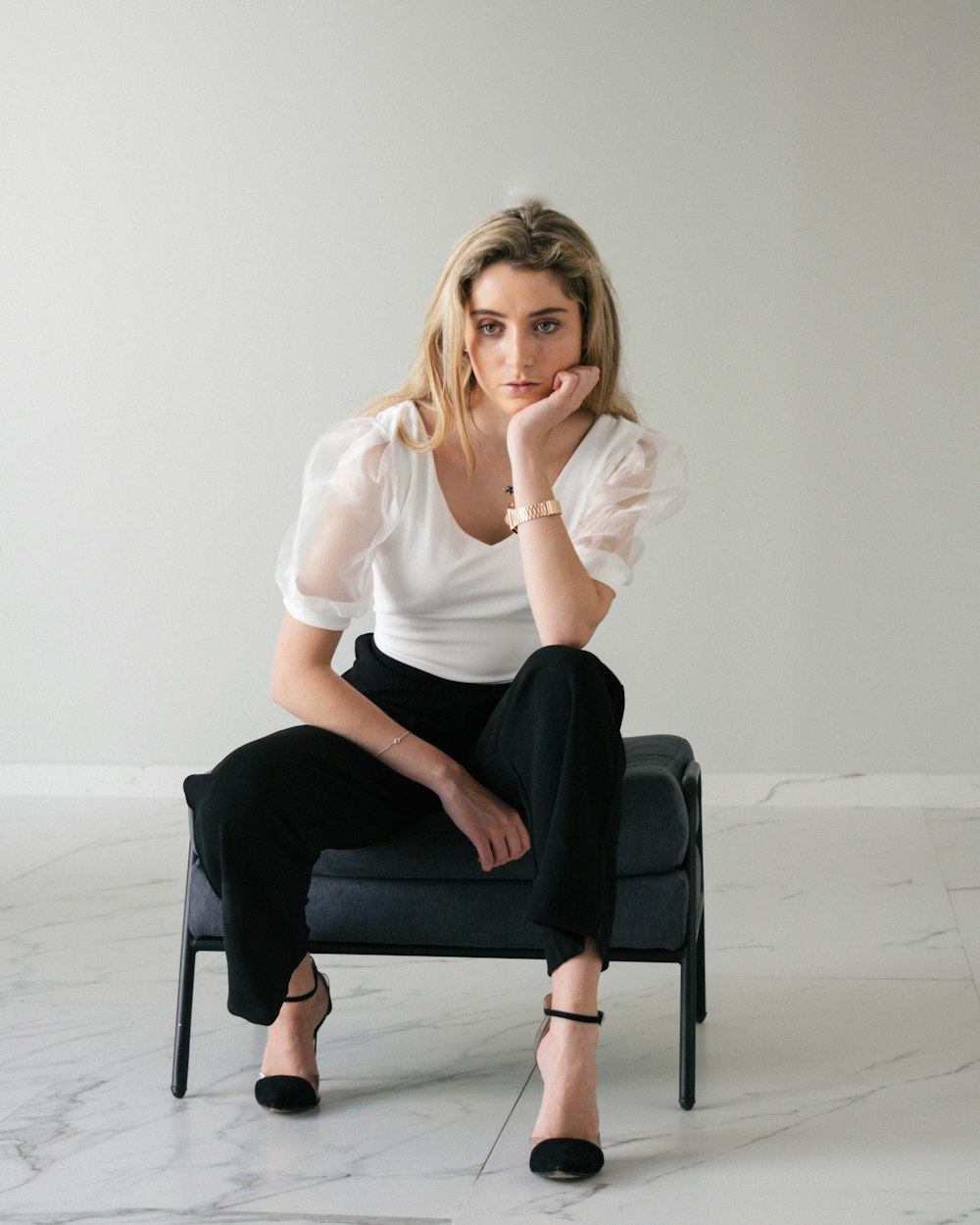 a woman sitting on top of a black chair