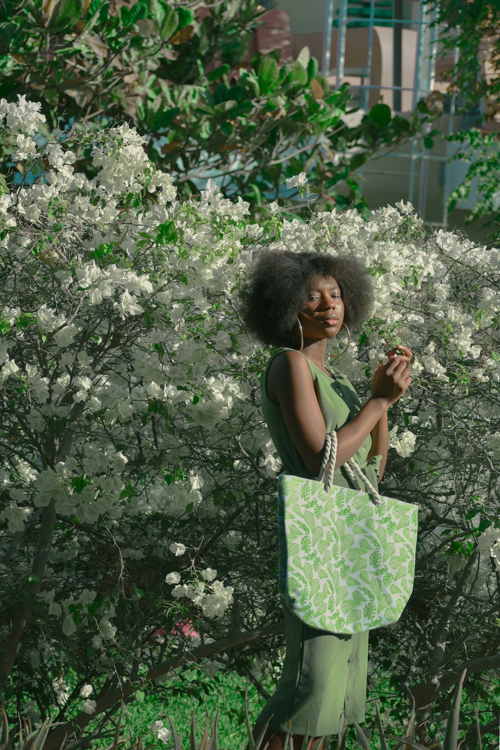 a woman in a green dress holding a green bag