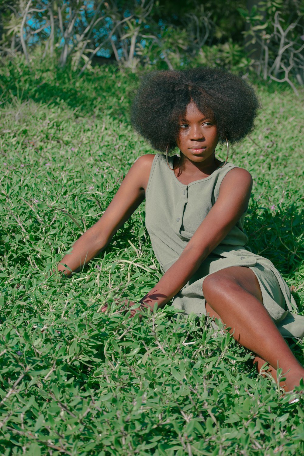 a young girl sitting in a field of grass