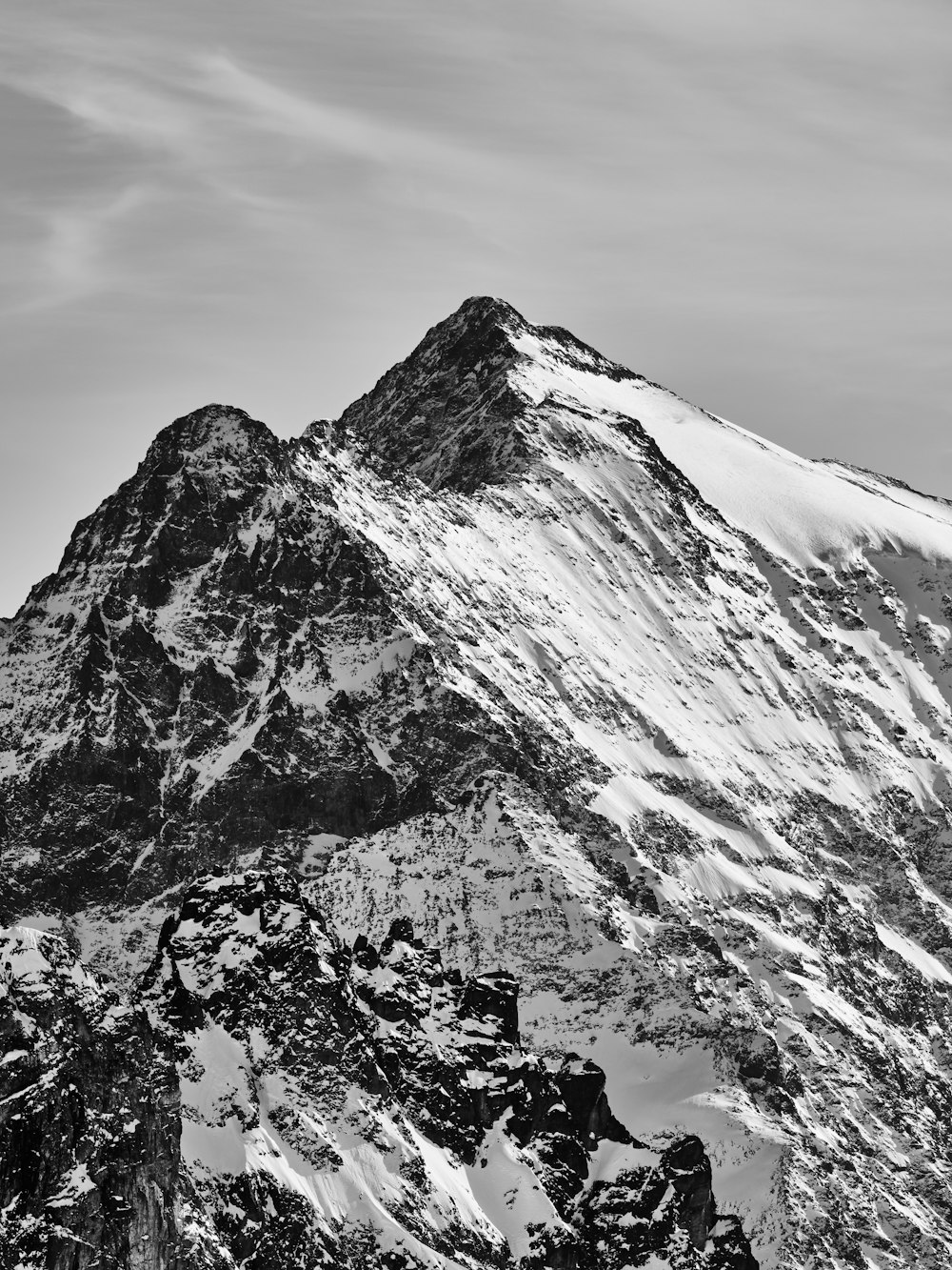 a black and white photo of a snow covered mountain