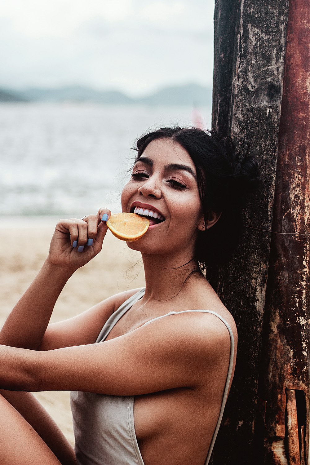  a woman sitting on the beach brushing her teeth