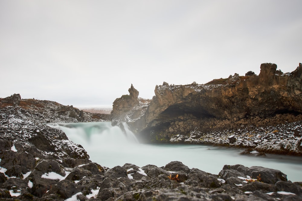 a small waterfall in the middle of a rocky area