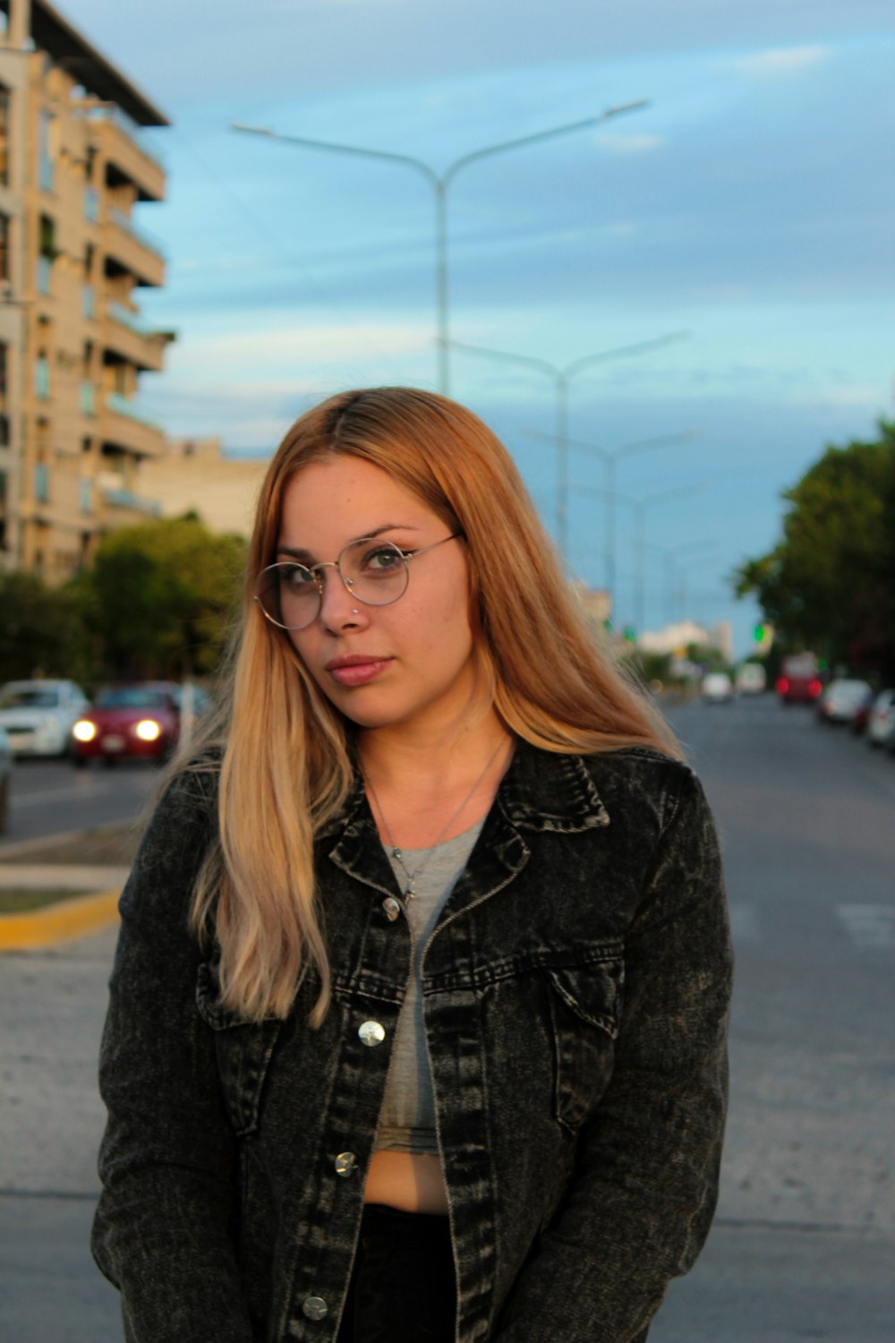 a woman standing on the side of a road