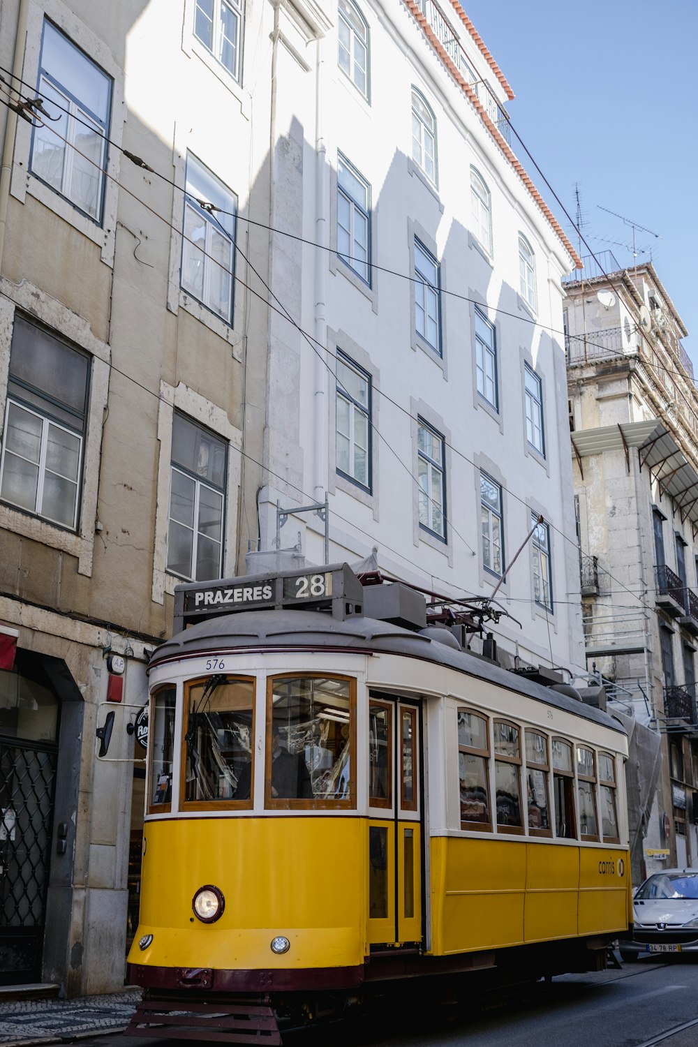 um bonde amarelo viajando por uma rua ao lado de edifícios altos