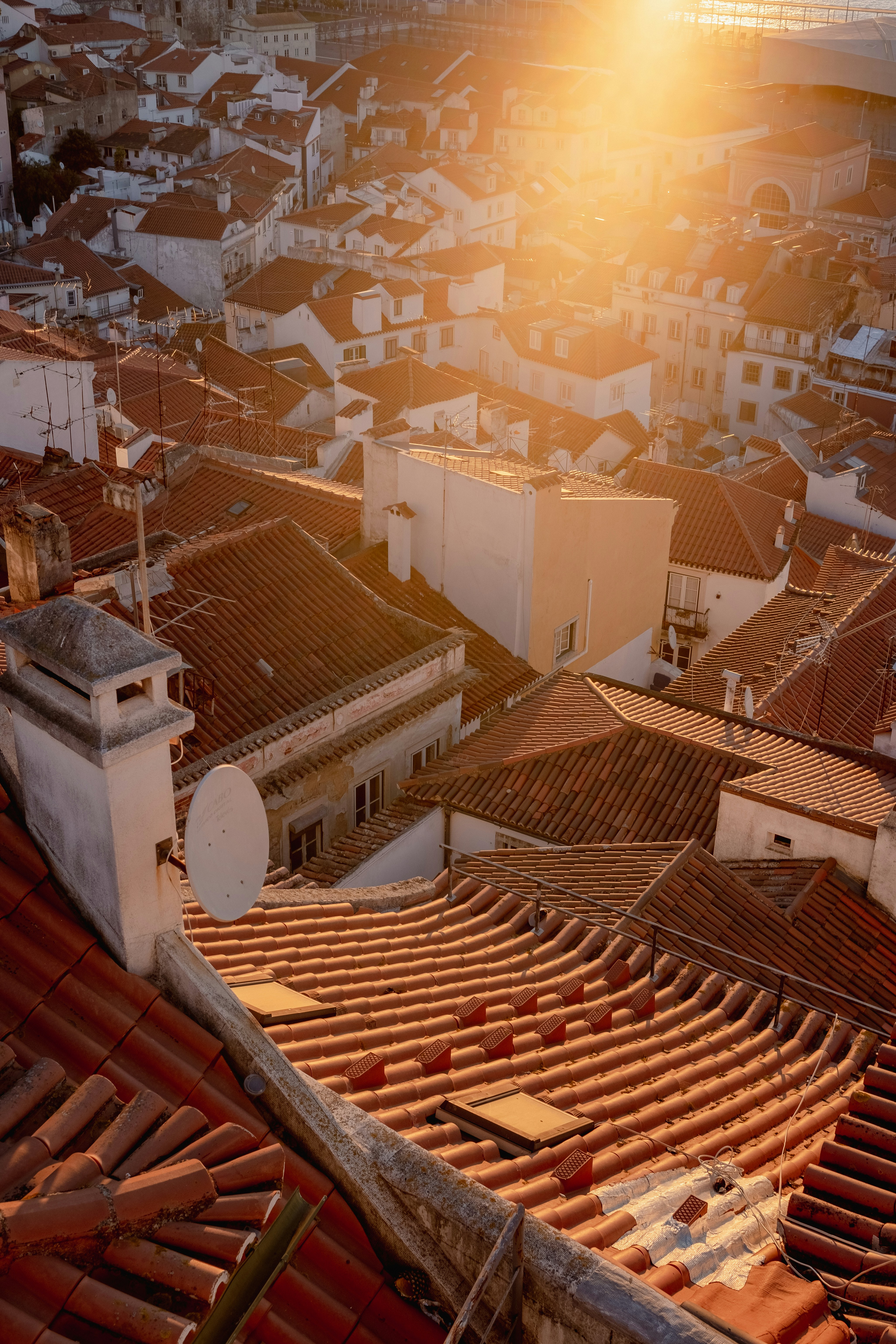 the sun shines brightly over a rooftop of a city