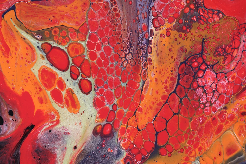 a close up of a painting with red and yellow colors