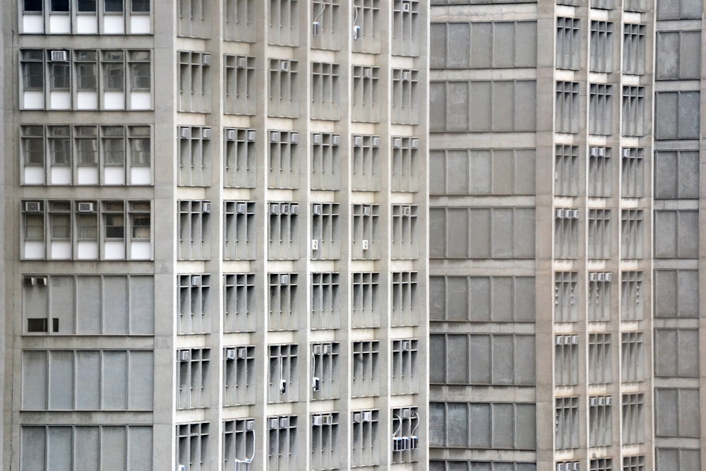 a tall building with lots of windows next to a parking meter