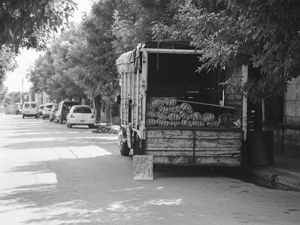a black and white photo of a truck full of produce