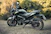 a black motorcycle parked in a grassy field