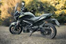 a black motorcycle parked in a grassy field