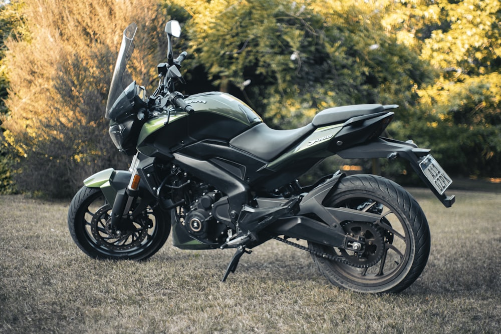 a black motorcycle parked in a grassy field