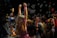 Children are gathered in a dark environment, with one child in the foreground raising arms surrounded by bubbles. Neon bracelets and colorful outfits suggest a festive atmosphere. Multiple children, some of whom seem to be playing, are involved in what looks like a party or event.