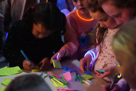 a group of children are playing with sticky notes