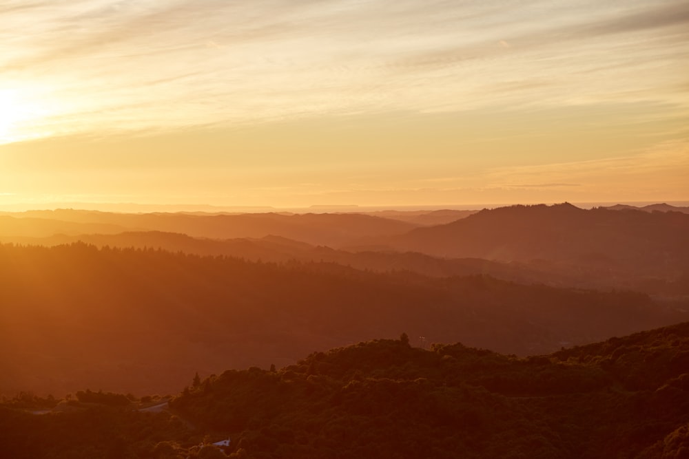 the sun is setting over a mountain range