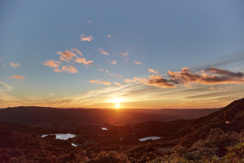 the sun is setting over a mountain range