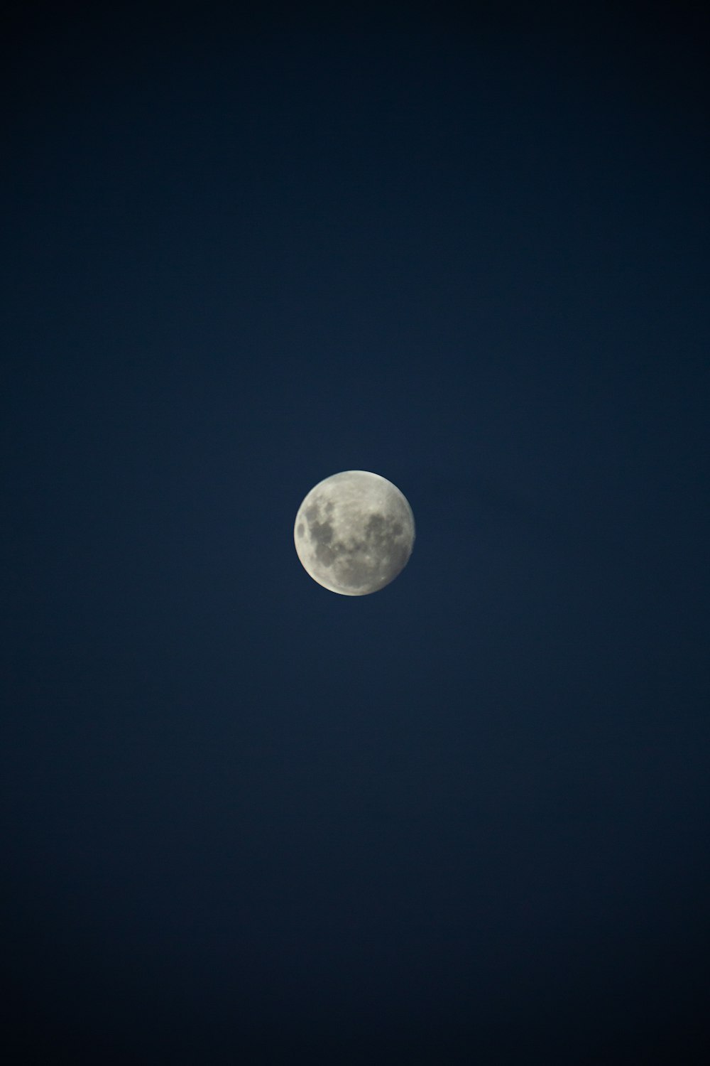 a full moon in a dark blue sky