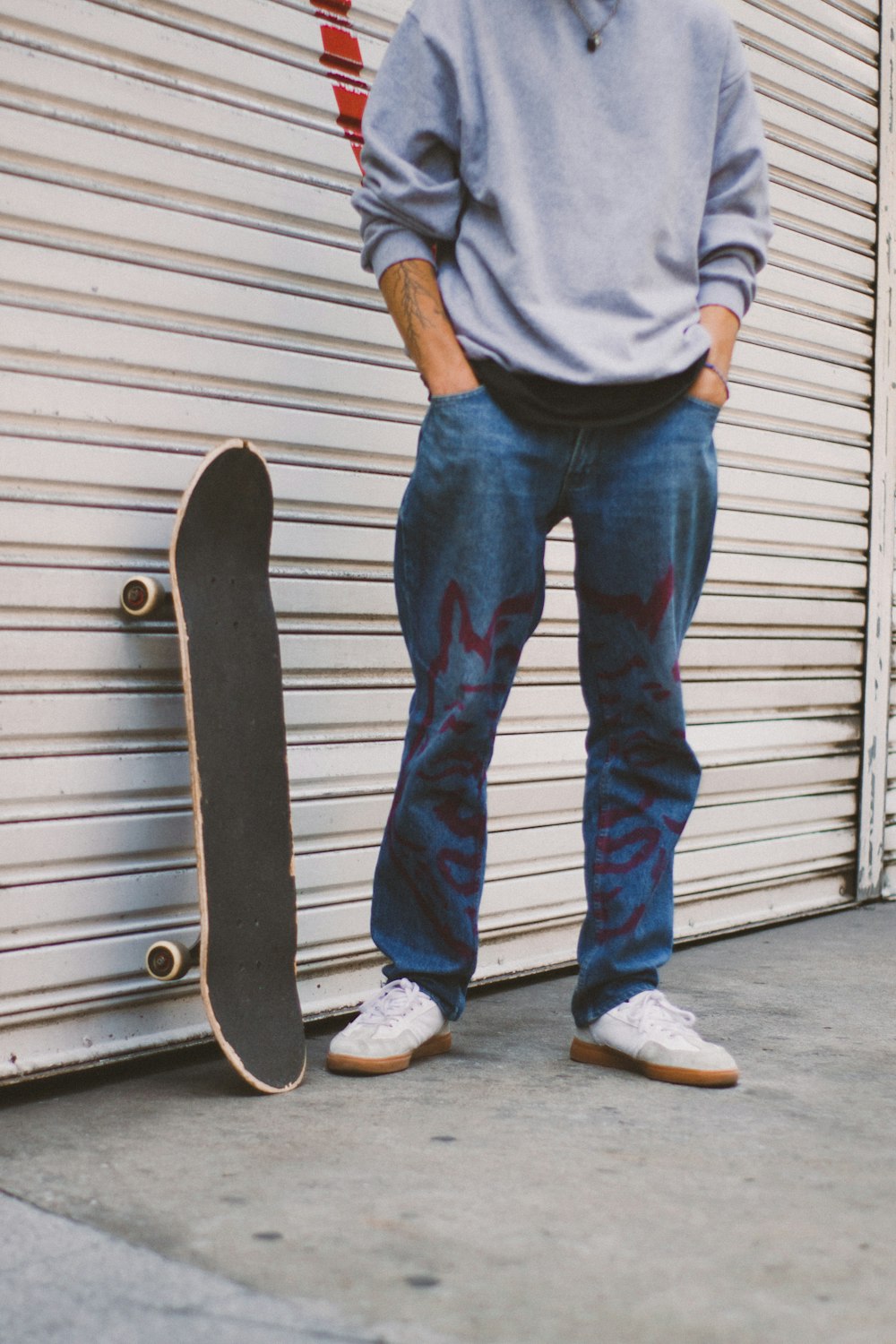 a man standing next to a skateboard in front of a garage door